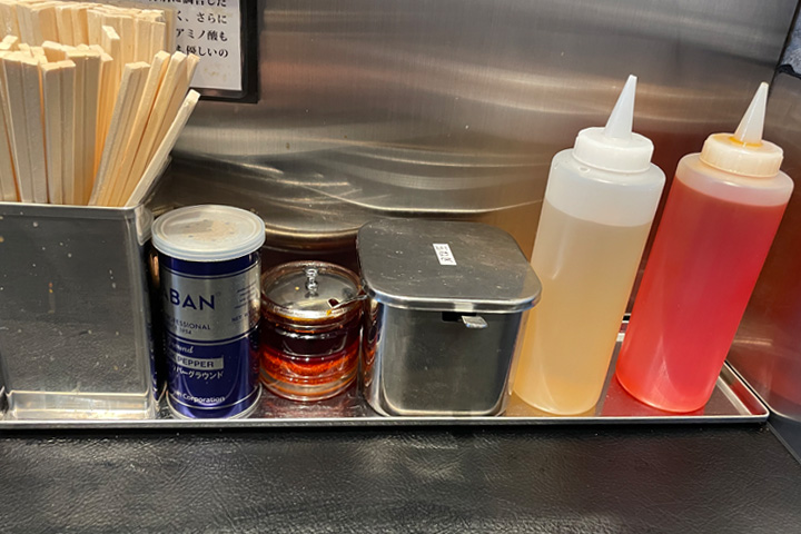 東京油組総本店 茨木組の卓上に置いてあるお酢とラー油